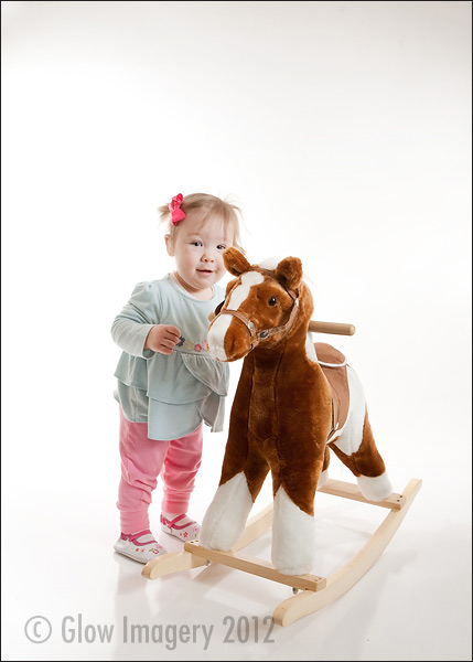 A baby celebrates her first-year with a cupcake in a Kansas City photographer's studio
