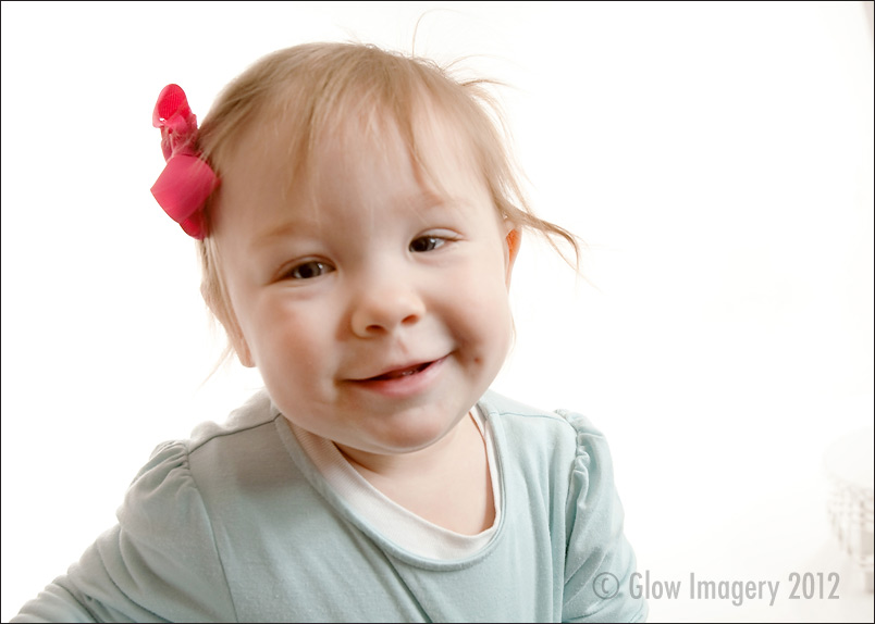 A baby celebrates her first-year with a cupcake in a Kansas City photographer's studio