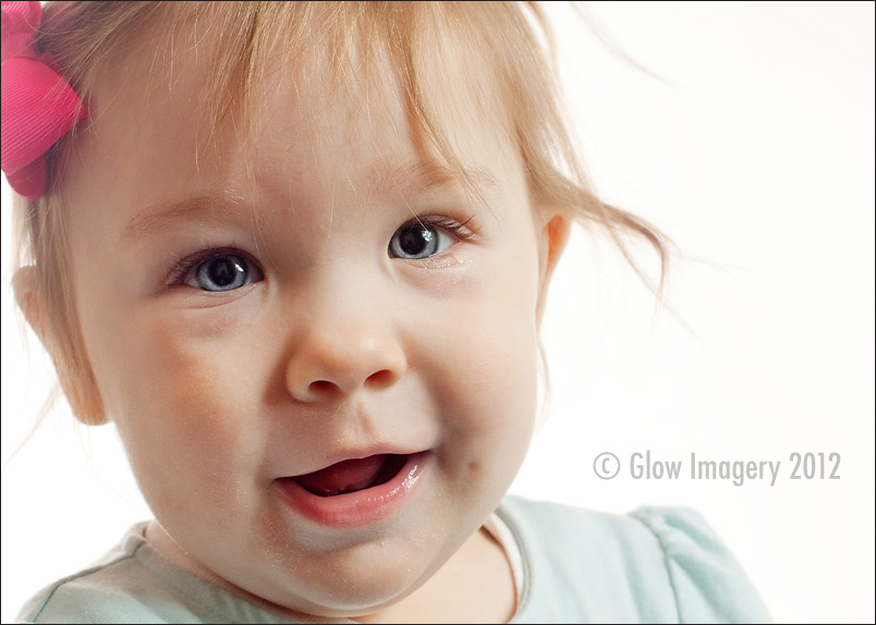 A baby celebrates her first-year with a cupcake in a Kansas City photographer's studio